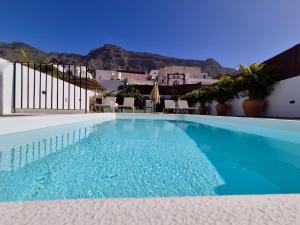 a swimming pool with blue water in front of a building at Casa Federico & Manuela – Piscina Climatizada in Mogán