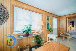 a living room with a table and a bedroom at Cg Beach Bungalow #1 in Myrtle Beach
