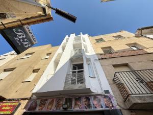 a tall white building with a window on the side of it at Agi Porthos Apartments in Roses