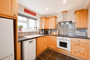 a kitchen with wooden cabinets and white appliances at 1 Bed in Debach oc-lasn in Debach