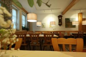 a dining room with tables and chairs and a clock at Gasthaus Grüner Baum in Prichsenstadt