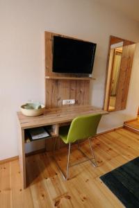 a room with a desk with a television and a chair at Gasthaus Grüner Baum in Prichsenstadt