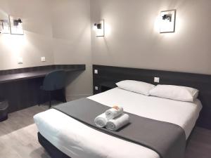 a hotel room with a bed with two towels on it at Hôtel Le Bratoria, anciennement Le Saint Vincent in Vourles
