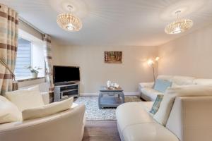 a living room with white furniture and a flat screen tv at 6 Bed in Great Waldingfield oc-ac4 in Waldingfield