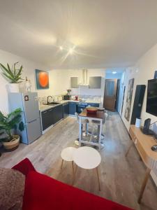 a room with a kitchen and a living room with a table at Hôte Labyrinthe sur la place chambres d, hôtes , calme ,Netflix in Mirepoix