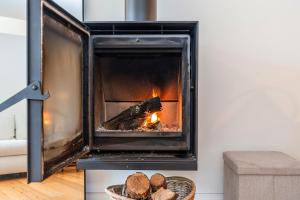 a fireplace in a living room with a fire at Foz Velha River House in Porto +24 photos