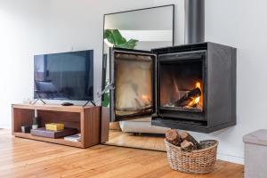 a living room with a fireplace and a tv at Foz Velha River House in Porto