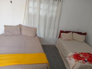 a bedroom with two beds and a window at DOUBLE e RETIRO das PRINCESAS aluguel de quartos in Salinópolis