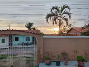 a house with a fence and a palm tree at DOUBLE e RETIRO das PRINCESAS aluguel de quartos in Salinópolis