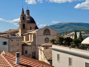 a view of a city with a church and roofs at The Q House in Foligno