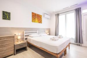 a bedroom with a large white bed with white sheets at MAGGIORE Affittacamere in Ravenna