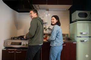 a man and a woman standing in a kitchen at cozy 3rd stay in Okayama