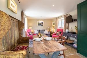 a living room with a wooden table and pink chairs at 1 Bed in Brassington oc-dcneb in Brassington