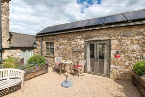 a stone cottage with a table and chairs in front of it at 1 Bed in Brassington oc-dcneb in Brassington