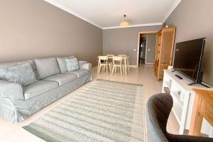 a living room with a couch and a flat screen tv at Marta Apartment - Balcony, Patio, Pool in Ferrel