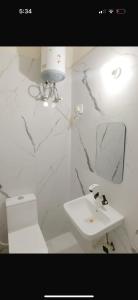 a white bathroom with a sink and a mirror at Hotel Royale Elite RK Residency in Vrindāvan