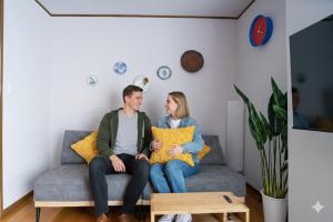 a man and woman sitting on a couch in a living room at cozy 3rd stay in Okayama +13 photos