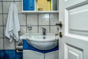 a bathroom with a white sink and a mirror at Mainades Maisonettes & Studios - Andros Serene Escape in Ménites