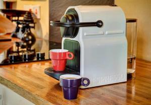 Eine Kaffeemaschine mit zwei Tassen steht auf der Küchentheke. in der Unterkunft Alde Barn in Stonham Aspall