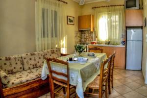 a living room with a table and a couch and a kitchen at Mainades Maisonettes & Studios - Andros Serene Escape in Ménites