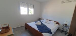 a bedroom with a bed with white sheets and a window at CASA VIGNA - villa T4 piscine privée in Sainte-Lucie de Porto-Vecchio