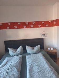ein Schlafzimmer mit einem Bett und zwei Kissen darauf in der Unterkunft Piacere Emden in Emden