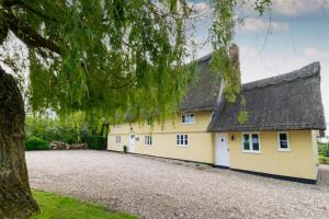 a yellow house with a black roof and a driveway at 5 Bed in Finningham oc-obhf in Finningham