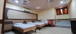 a hospital room with four beds and a chalkboard at Hotel Shri Shanti Niwas in Bikaner