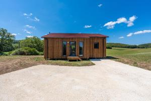 a small wooden house with a bench in a field at Maison 3 pièces, climatisé, calme, "Le chalet" in Carlux