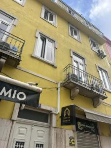 a yellow building with balconies on the side of it at Daora Lisbon Beds in Lisbon +18 photos