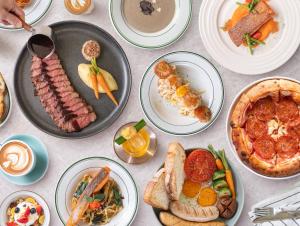 a table with plates of food on it at Saan Hotel Sathorn in Bangkok