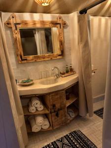 a bathroom with a sink and a mirror at Peaceful Luxury Camp in Merzouga