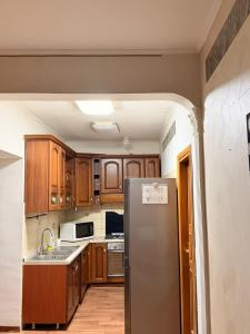 a kitchen with wooden cabinets and a stainless steel refrigerator at Victoria guesthouse in Rome