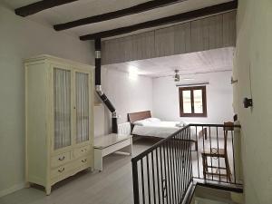 a room with a bedroom and a bed and a staircase at CAL MA Ponts in Ponst