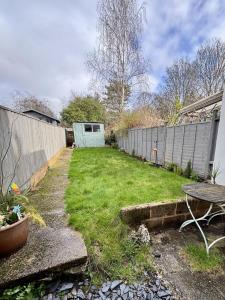 a yard with a fence and a table in a yard at Nadder Lodge - Salisbury in Old Sarum