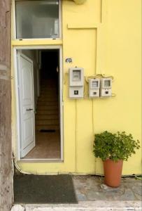 a yellow building with a door and a stair case at Pelagos Apartments in Myrtos