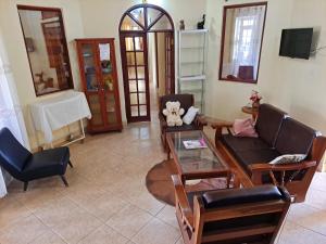 a living room with a couch and a table and chairs at Rainbow Executive Lodge in Boma la Ngombe