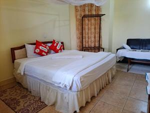 a bedroom with a large white bed with red pillows at Rainbow Executive Lodge in Boma la Ngombe