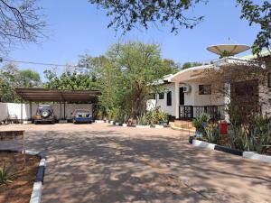 a garage with a car parked in front of a house at Rainbow Executive Lodge in Boma la Ngombe