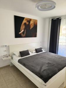a bedroom with a bed with a picture of an elephant at Casa de Rufio With Pool Tenerife in Puerto de Santiago +11 photos
