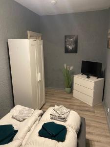 a room with two beds and a white refrigerator at Flensburg Zentrum 50 01 in Flensburg
