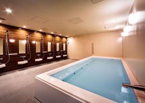 a bathroom with a large tub and a row of sinks at Awa Kanko Hotel in Tokushima