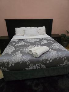 a bed with two towels on top of it at Dreamy Den Suites Kiwatule in Kampala