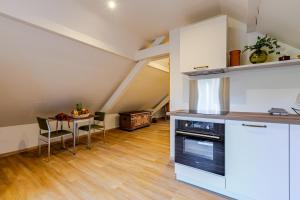 a kitchen and dining room with a table in an attic at Romantic 4-star suite with private heated pool in Gimbrett