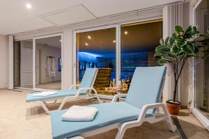 two blue chairs and a table on a balcony at Romantic 4-star suite with private heated pool in Gimbrett