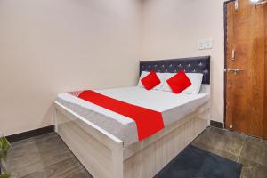a bedroom with a bed with red pillows at Hotel O Goyal Inn in Nagpur