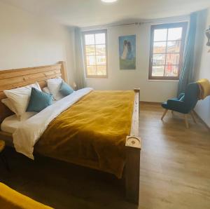 a bedroom with a large bed and a chair at Hôte Labyrinthe sur la place chambres d, hôtes , calme ,Netflix in Mirepoix