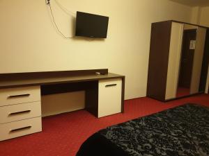 ein Hotelzimmer mit Schreibtisch und Fernseher an der Wand in der Unterkunft Casa Marly in Caracal
