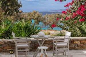 a patio with a table and chairs and flowers at Thalassa Naxos in Kastraki