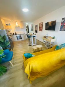 a living room with a yellow couch and a table at Hôte Labyrinthe sur la place chambres d, hôtes , calme ,Netflix in Mirepoix